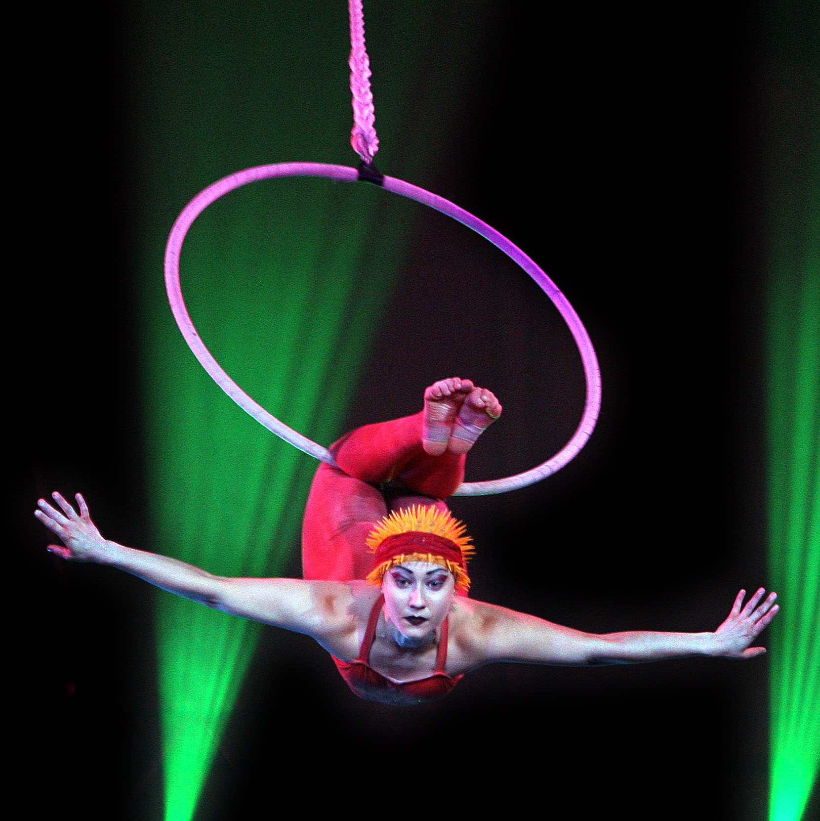 Individual performing on an aerial hoop.